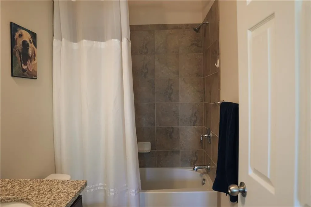 Full bathroom featuring shower / bath combination with curtain, toilet, and vanity
