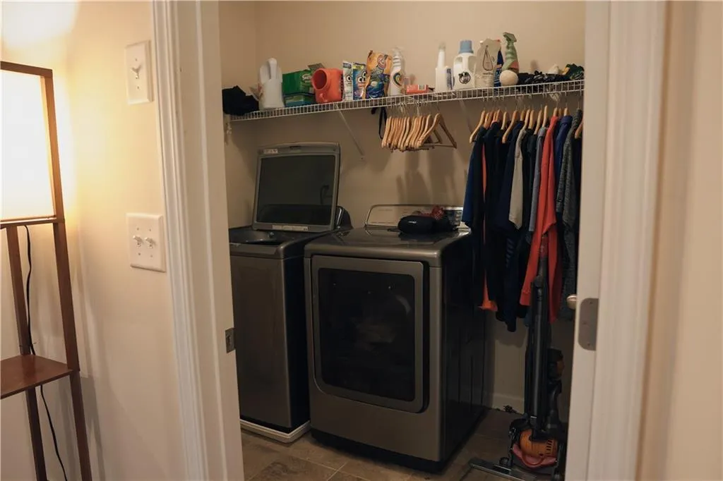 Laundry area with tile patterned flooring and separate washer and dryer