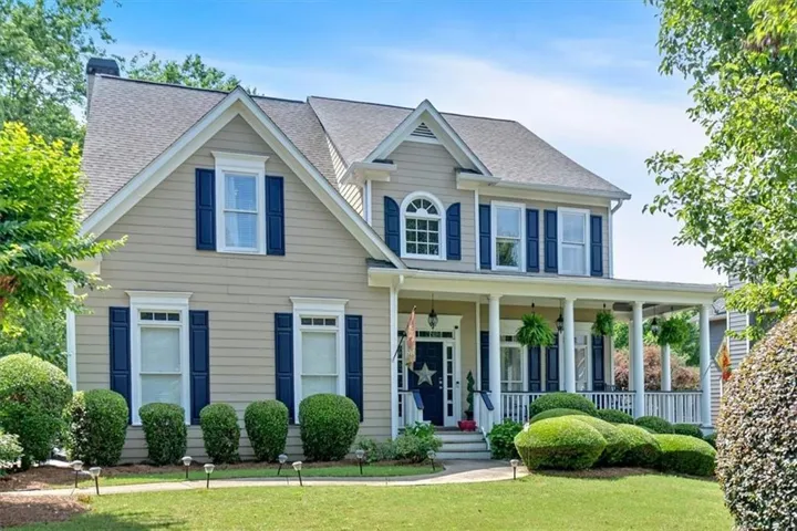 Two-story residence featuring light tan siding and a dark shingled roof