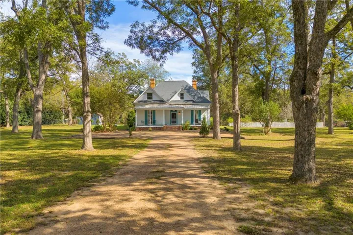 Victorian-style home featuring a covered front porch, light blue shutters, and a dormer window