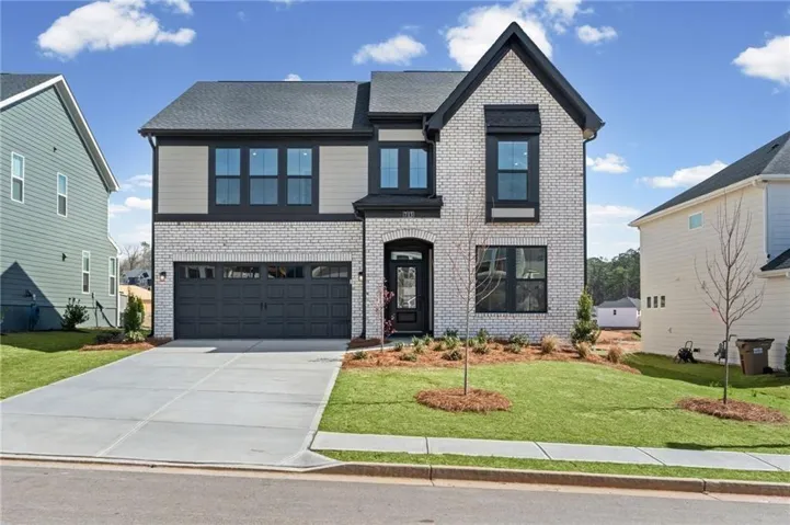 View of front of home featuring a front lawn, brick siding, concrete driveway, an attached garage, and a shingled roof