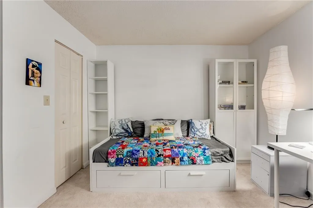 Bedroom featuring light colored carpet and a closet