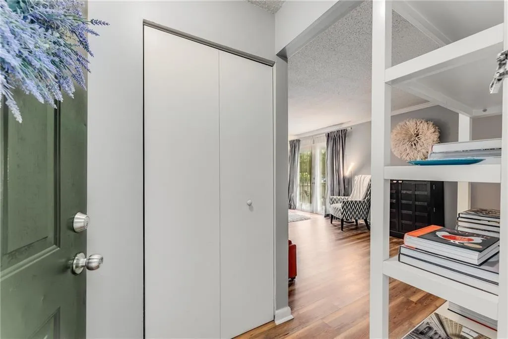 Corridor with a textured ceiling and light wood finished floors