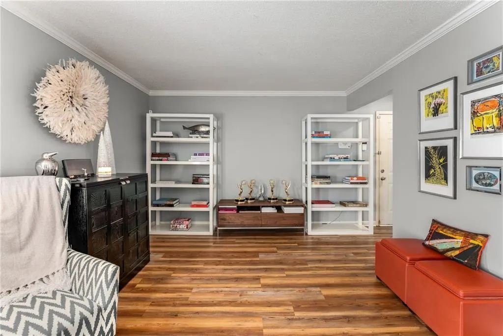 Sitting room with dark wood-style floors, crown molding, and a textured ceiling