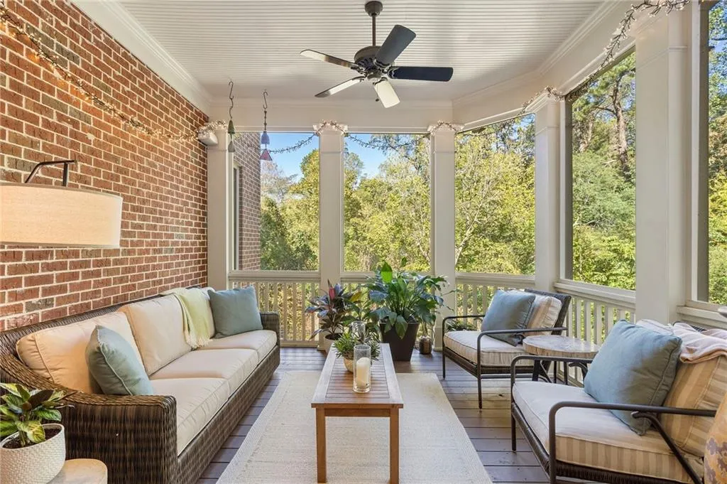 Sunroom / solarium with brick wall, outdoor lounge area, ceiling fan, hardwood / wood-style flooring, and ornamental molding Sunroom / solarium with brick wall, outdoor lounge area, ceiling fan, hardwood / wood-style flooring, and ornamental molding