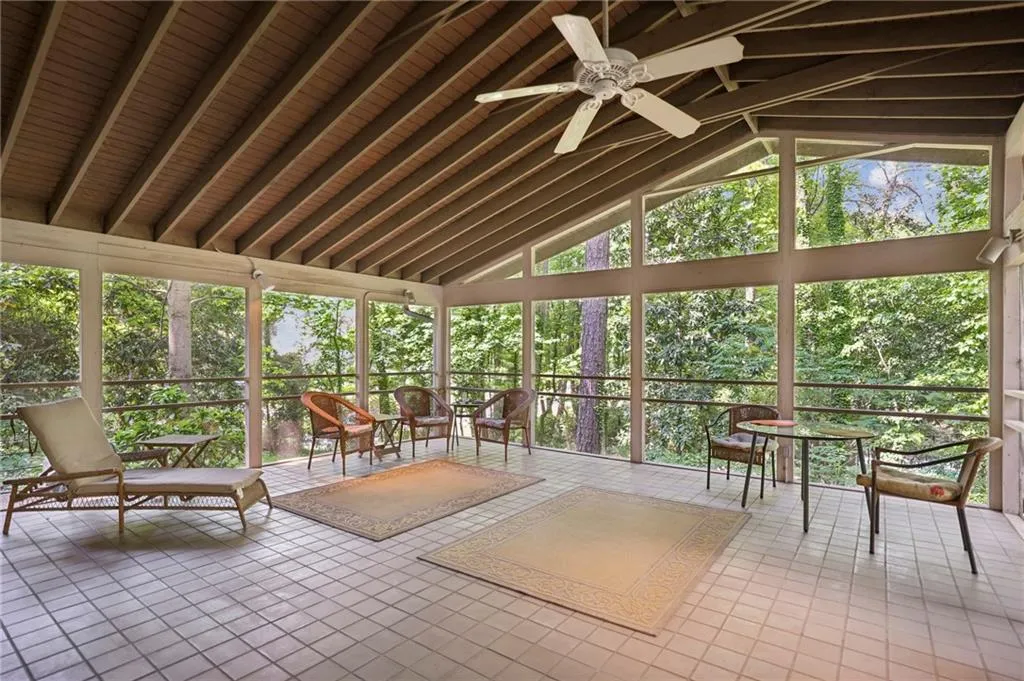 Large sunroom with wood ceiling, ceiling fan, and lofted ceiling with beams