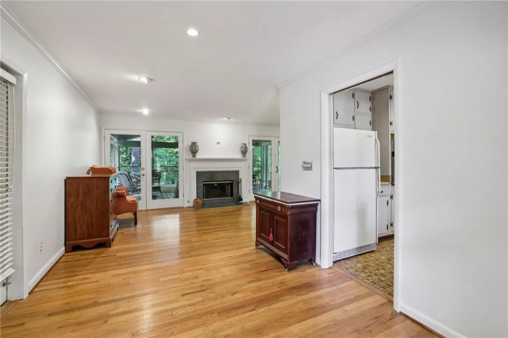 Living room with ornamental molding and light hardwood / wood-style floors