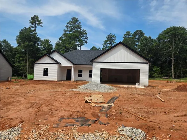 Contemporary new construction with white vertical and horizontal siding, a dark roof, and an integrated two-car garage