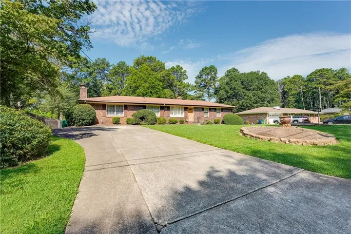 Brick exterior with a prominent chimney and a concrete driveway
