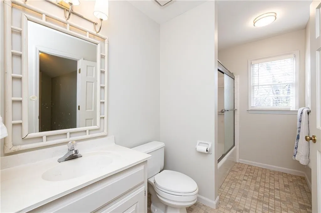 Full bath with vanity and combined bath / shower with glass door