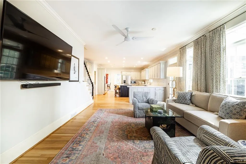 Living room with crown molding, light wood finished floors, and a ceiling fan