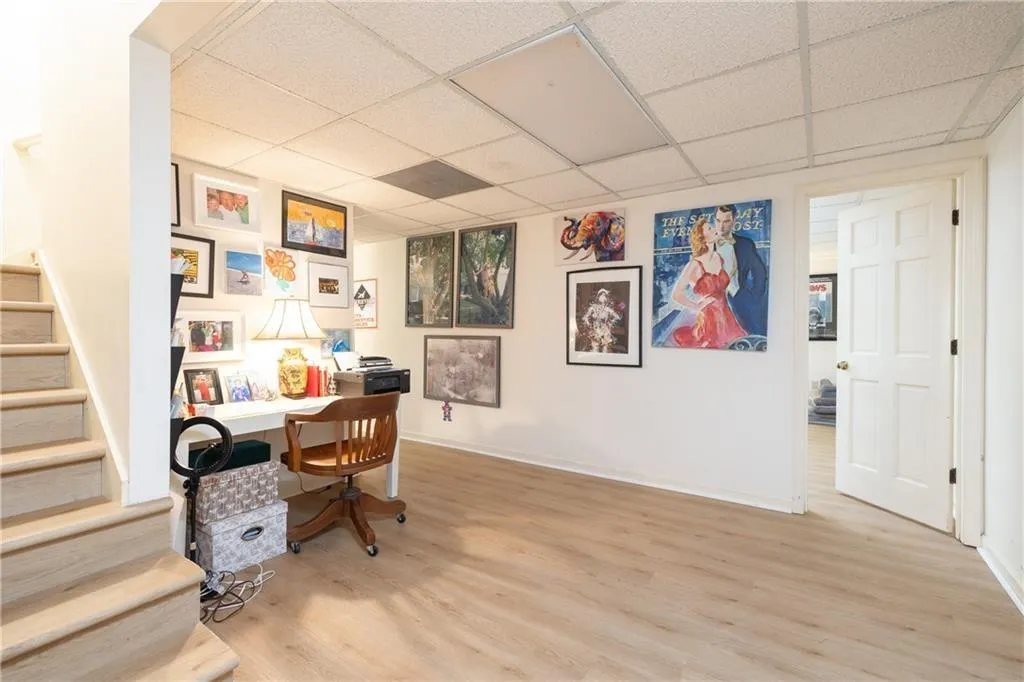 Office area featuring light wood-style floors and a paneled ceiling