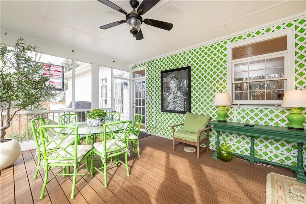 Sunroom featuring ceiling fan, a wooden deck, and outdoor dining space