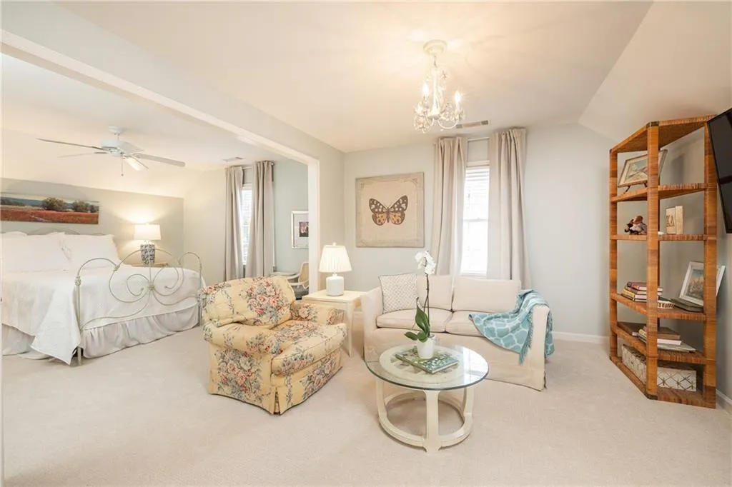 Living area featuring vaulted ceiling, carpet floors, a ceiling fan, and hanging lights