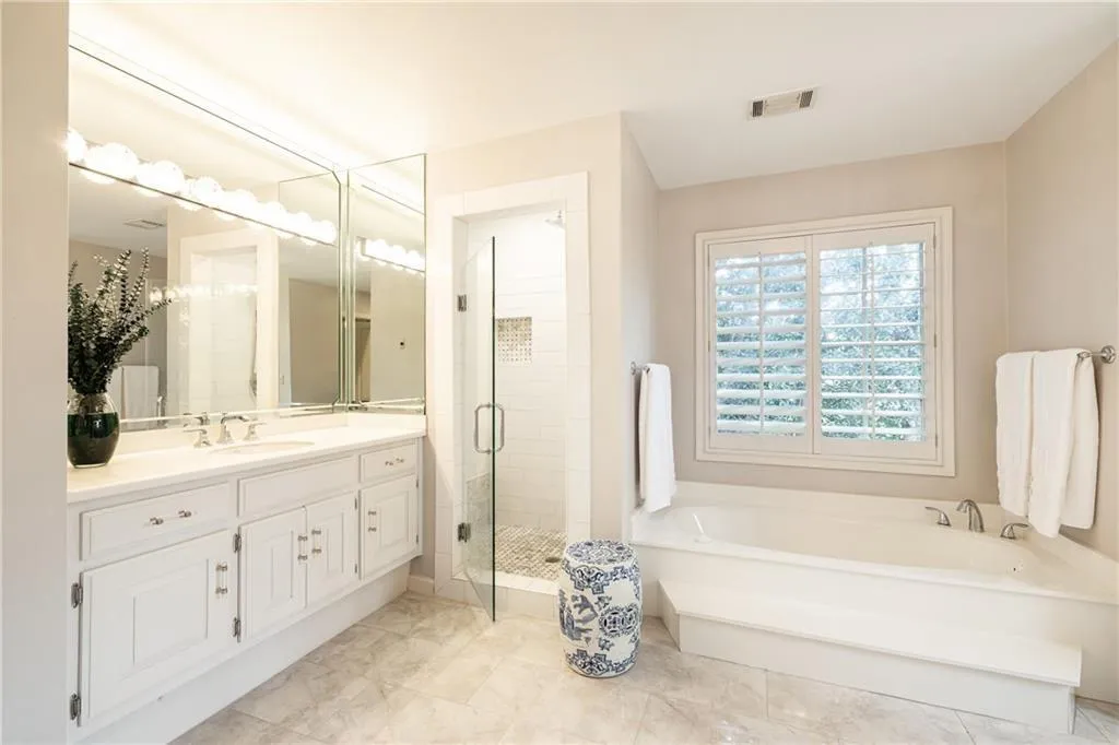 Full bathroom with vanity, a stall shower, and a bath