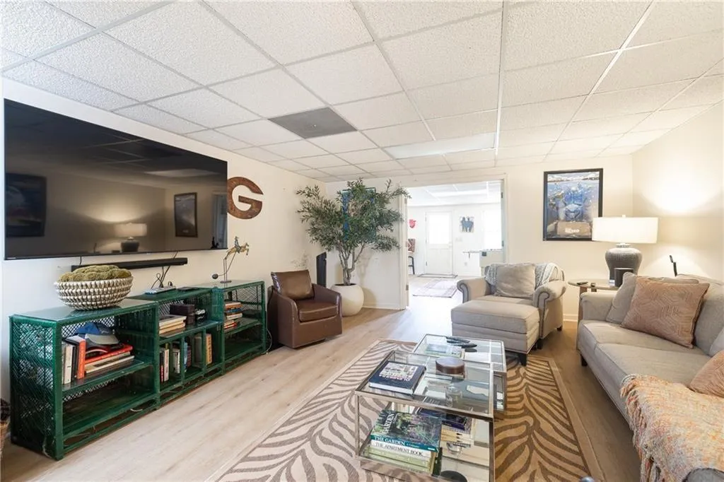 Living area featuring light wood-style flooring and a paneled ceiling