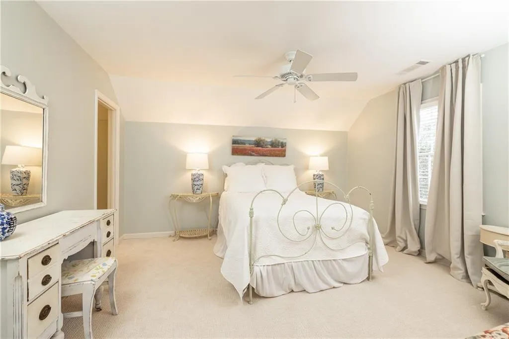 Bedroom with lofted ceiling, light colored carpet, and ceiling fan