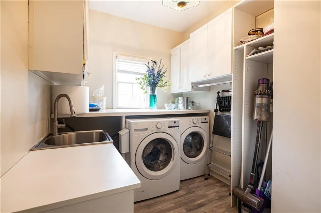 Laundry room featuring washing machine and clothes dryer, dark wood-type flooring, and cabinet space