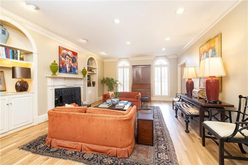 Living area featuring ornamental molding, light wood finished floors, built in shelves, a fireplace, and recessed lighting