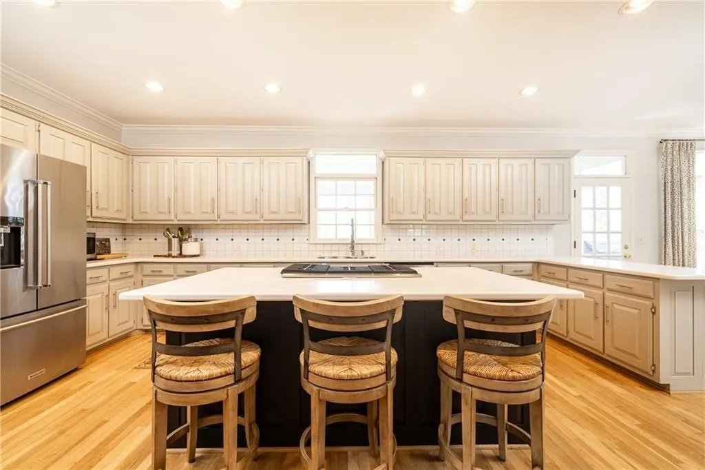 Kitchen featuring a breakfast bar area, stainless steel appliances, ornamental molding, a kitchen island, and recessed lighting