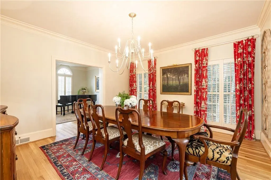 Dining space with ornamental molding, light wood-style flooring, and hanging lights
