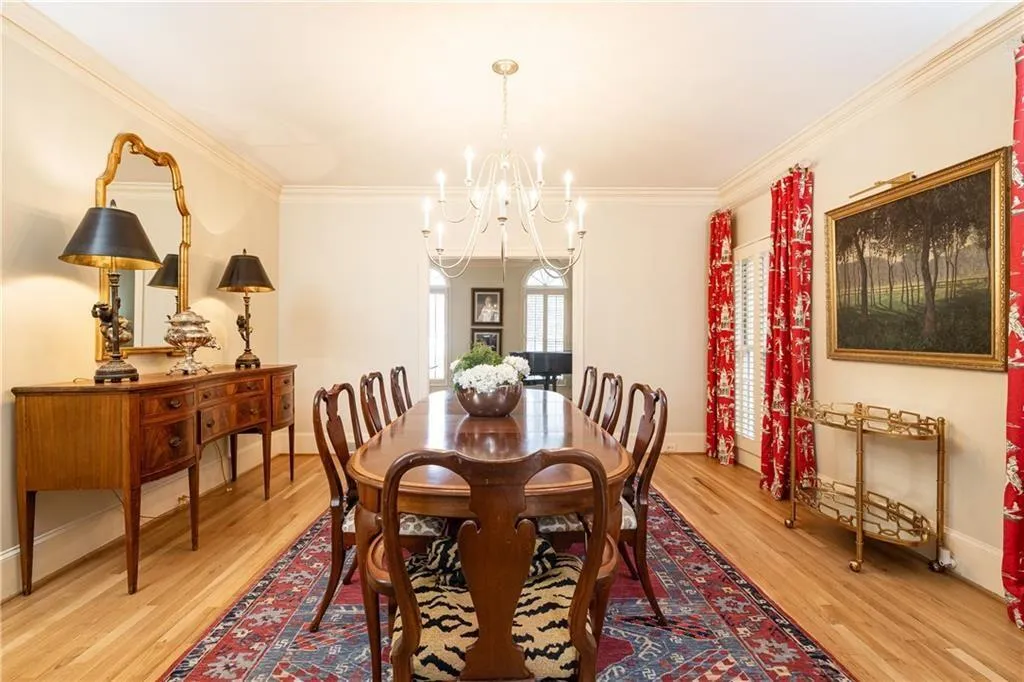 Dining room with suspended lighting, light wood-type flooring, and ornamental molding