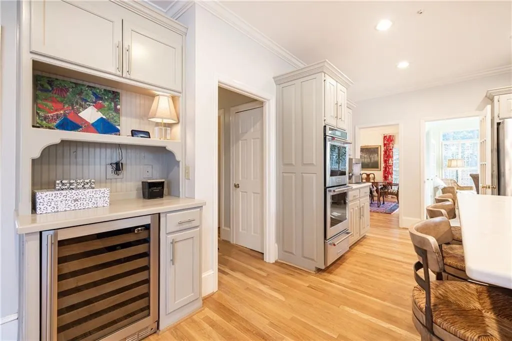 Kitchen with wine cooler, light wood-type flooring, recessed lighting, crown molding, and a warming drawer