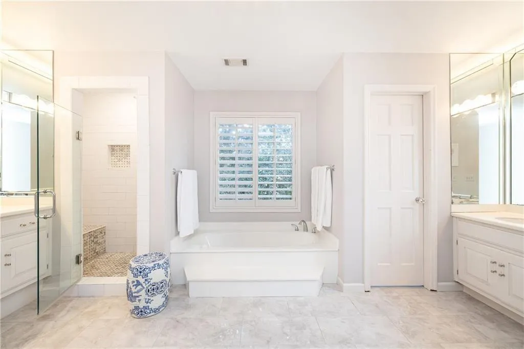 Bathroom with vanity, a tile shower, and a garden tub