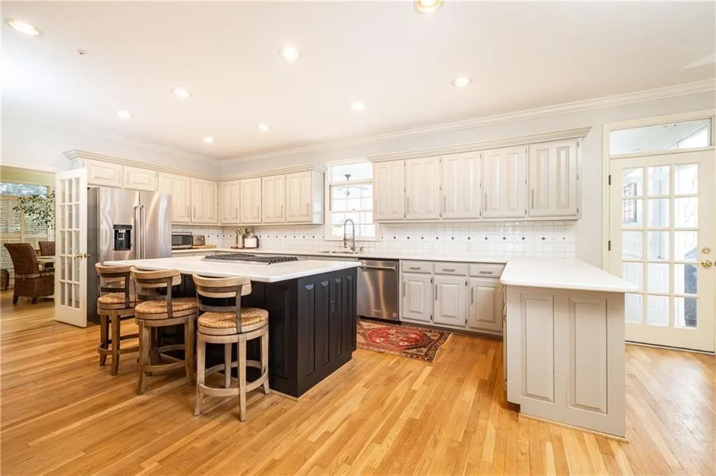 Kitchen featuring french doors, a kitchen breakfast bar, backsplash, a center island, and ornamental molding
