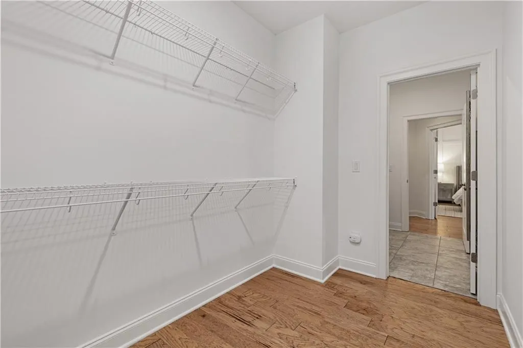 Walk in closet with wood-type flooring