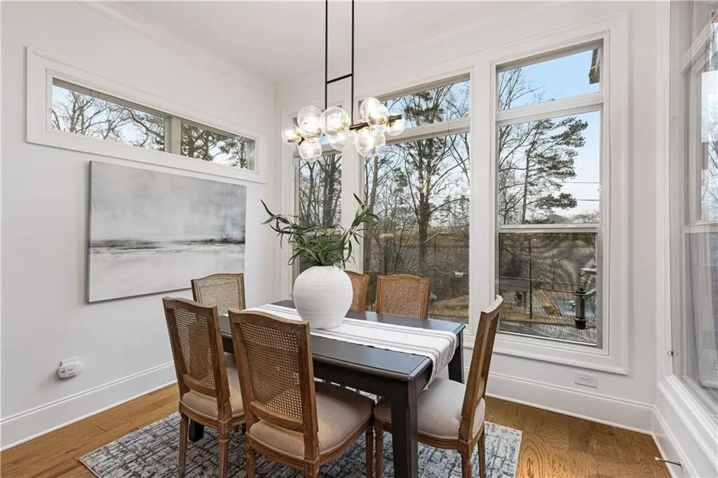 Dining room featuring wood-type flooring, ornamental molding, and a chandelier