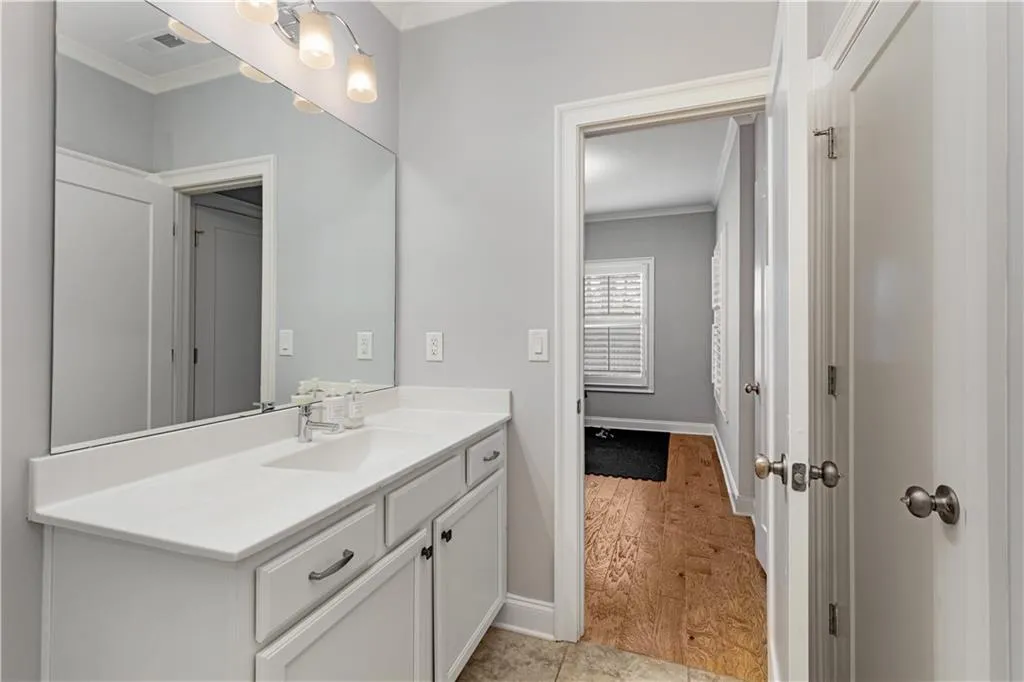 Bathroom with ornamental molding, vanity, and hardwood / wood-style floors