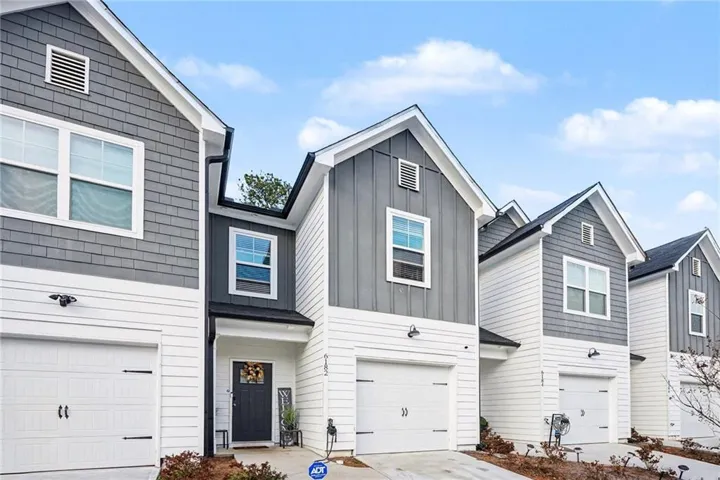 View of front of property featuring board and batten siding, an attached garage, and concrete driveway