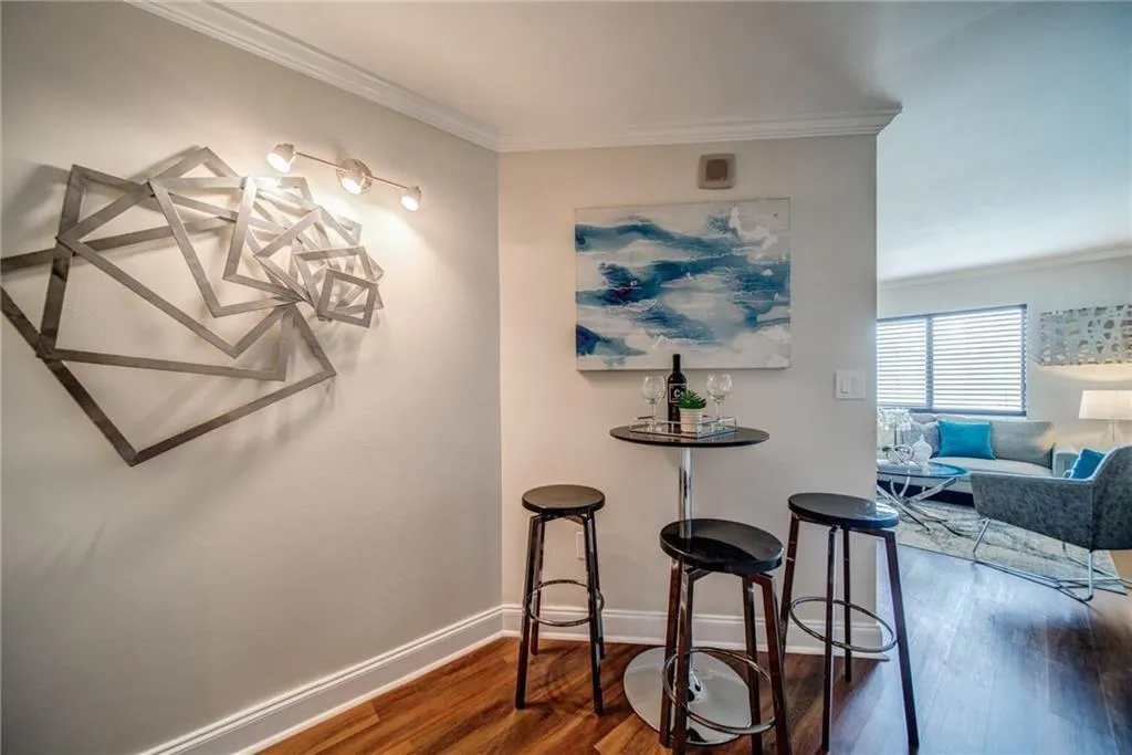 Dining space with ornamental molding and dark wood-type flooring