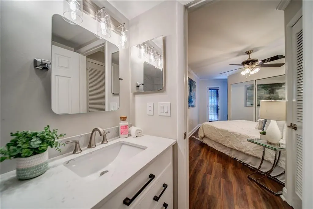 Bathroom with vanity, dark wood-type flooring, ornamental molding, a closet, and ceiling fan