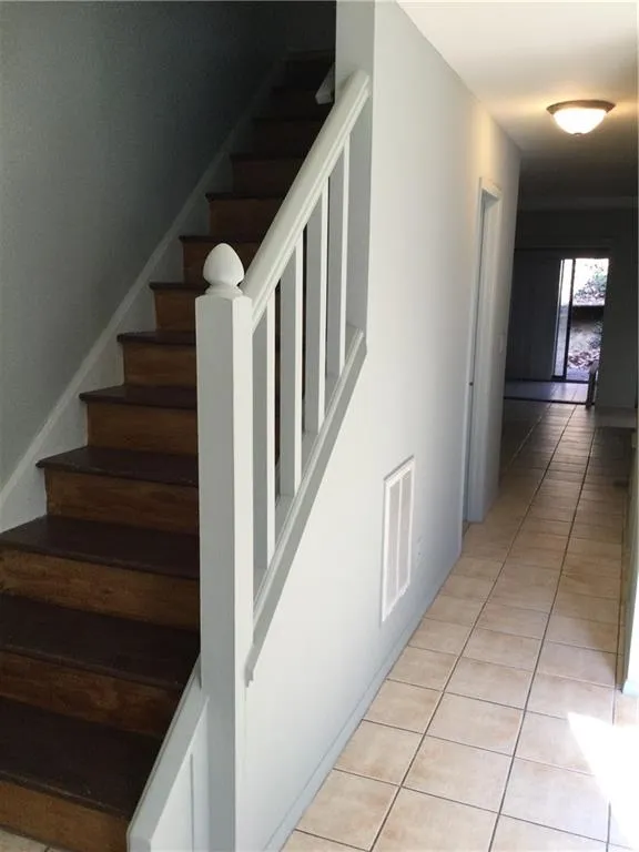 Stairs featuring tile patterned floors