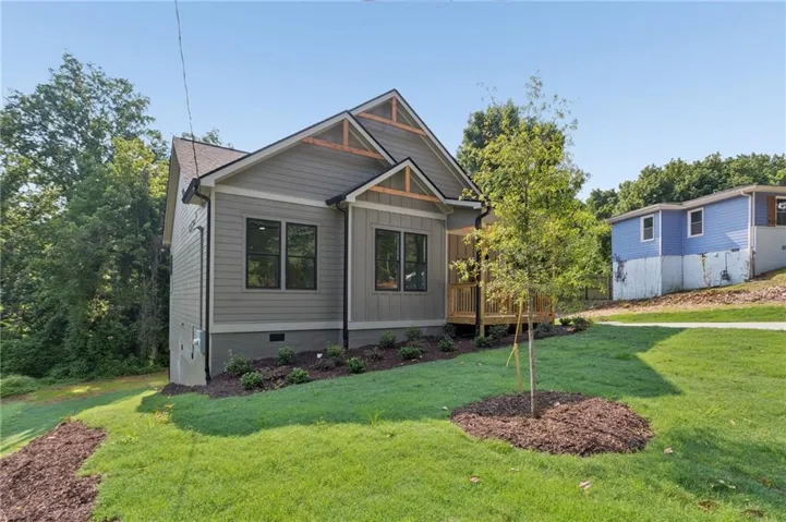 Contemporary home featuring grey siding, dark-framed windows, and decorative wood gables