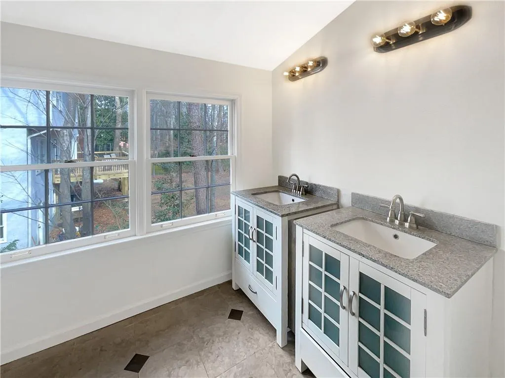 Bar featuring light stone countertops, light tile patterned floors, white cabinetry, lofted ceiling, and glass insert cabinets