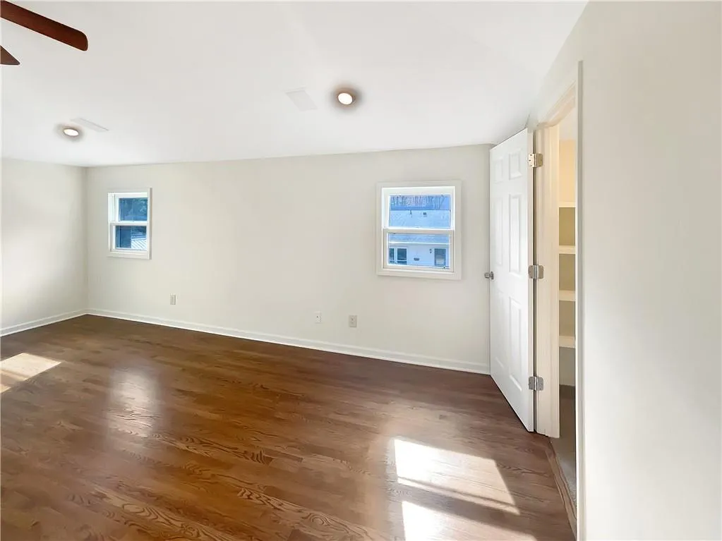 Unfurnished room featuring dark wood-style floors and a ceiling fan