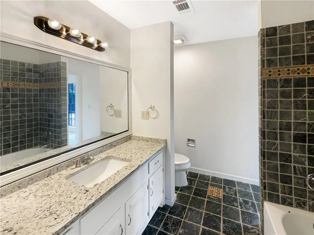 Full bath featuring shower / washtub combination, vanity, and a textured ceiling