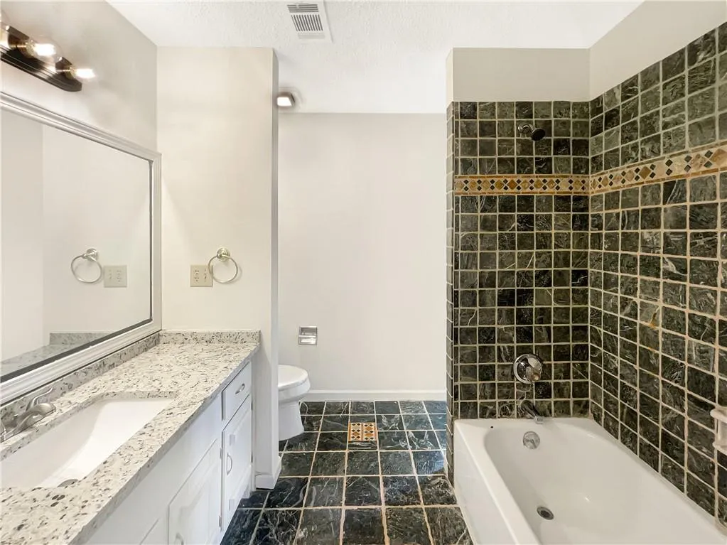 Full bathroom featuring vanity, shower / tub combination, and a textured ceiling