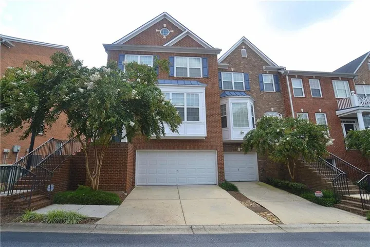 Brick townhome exterior featuring an attached two-car garage