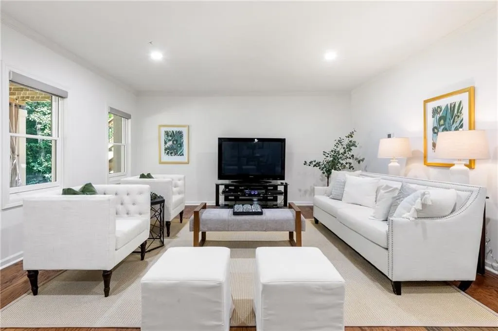 This basement-level home media center boasts 8'+ ceilings, hardwood floors, and abundant natural light. Wired for surround sound and projection, it features a full bar, bedroom, bath, second laundry, storage, and curbless patio access. Plumbed for a second kitchen, it's ideal as an in-law suite or roommate setup.