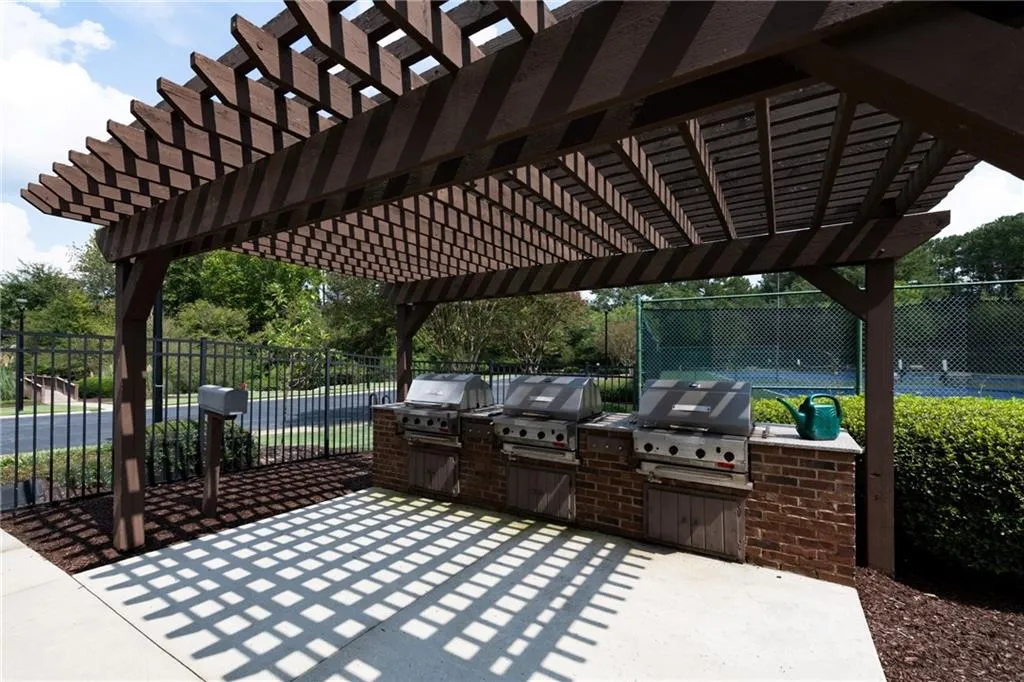 3 gas grills next to tennis courts, clubhouse and pool.