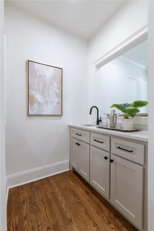 The main-level bar features custom cabinetry and a quartz countertop, with pass-through windows on both sides for effortless conversation and serving. The larger bar is located on the basement level.