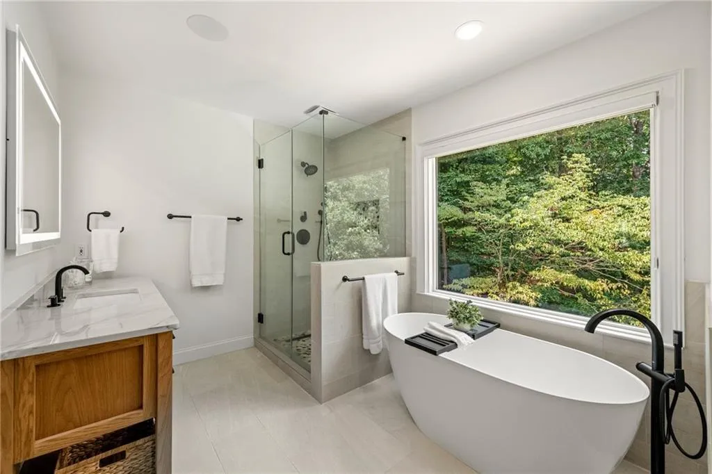 The soaking tub comfortably accommodates even tall individuals, while porcelain tile floors and walls create a serene, spa-like retreat to begin and end each day.