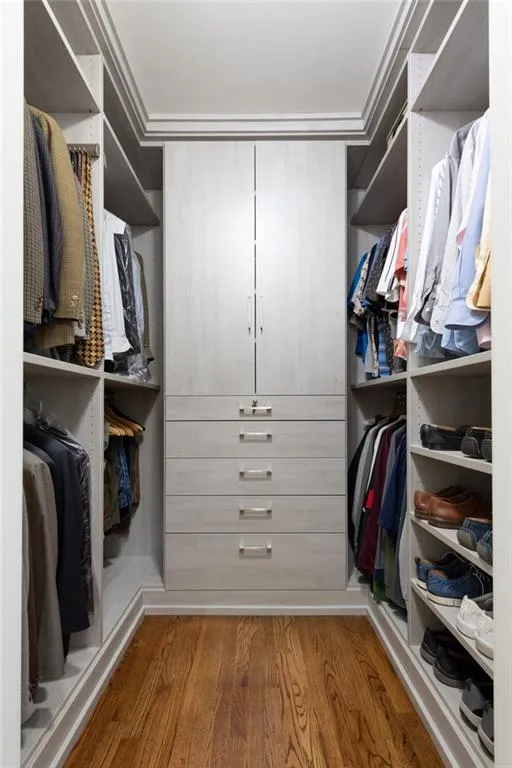 Primary Bedroom - his walk-in closet features custom built-ins with soft-close drawers and doors, including a lockable drawer. There's also two recessed tie racks that will hold over 60 ties. Fully adjustable shelving allows for effortless organization and flexibility.
