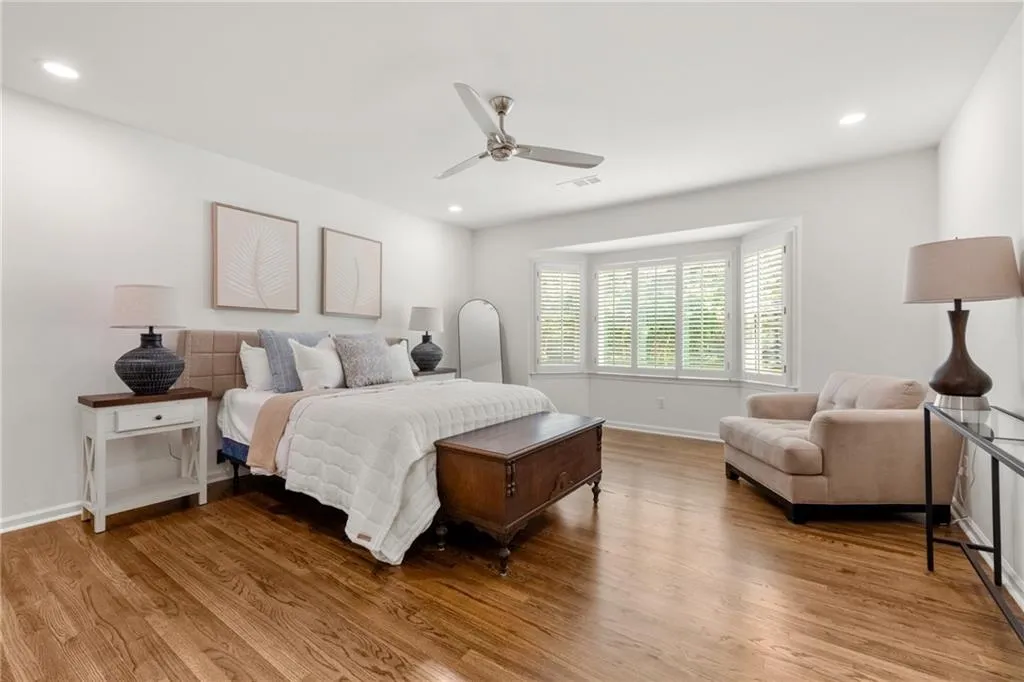 This spacious bedroom features elegant plantation shutters and ample room for a full furniture set. The ensuite bath offers dual sinks with quartz countertops and Kohler widespread faucets, a private shower, and modern finishes creating comfort, style, and convenience in one.