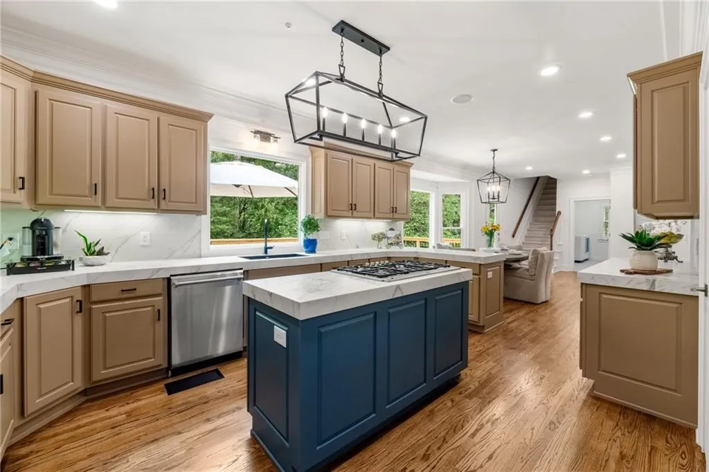 Chef's delight! Stylish kitchen with maple cabinets, porcelain countertops and backsplash, center island with Thermador 5-burner cooktop and stainless appliances combining elegance with everyday functionality.