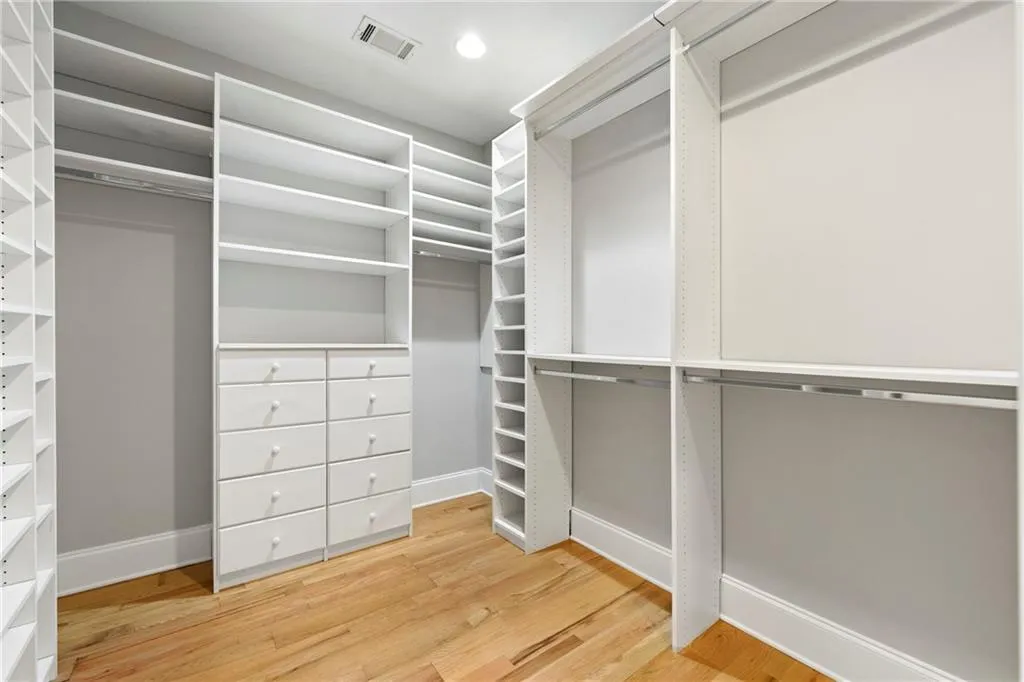 Huge Primary Bedroom Walk In Closet with tons of Organizing Shelves